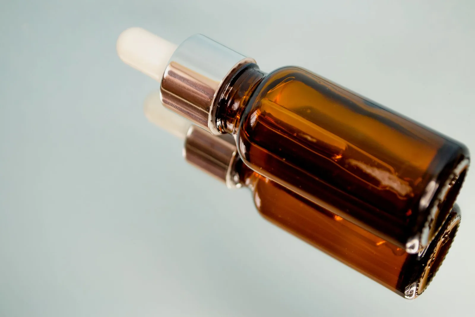 Amber glass dropper bottle on a soft pale background