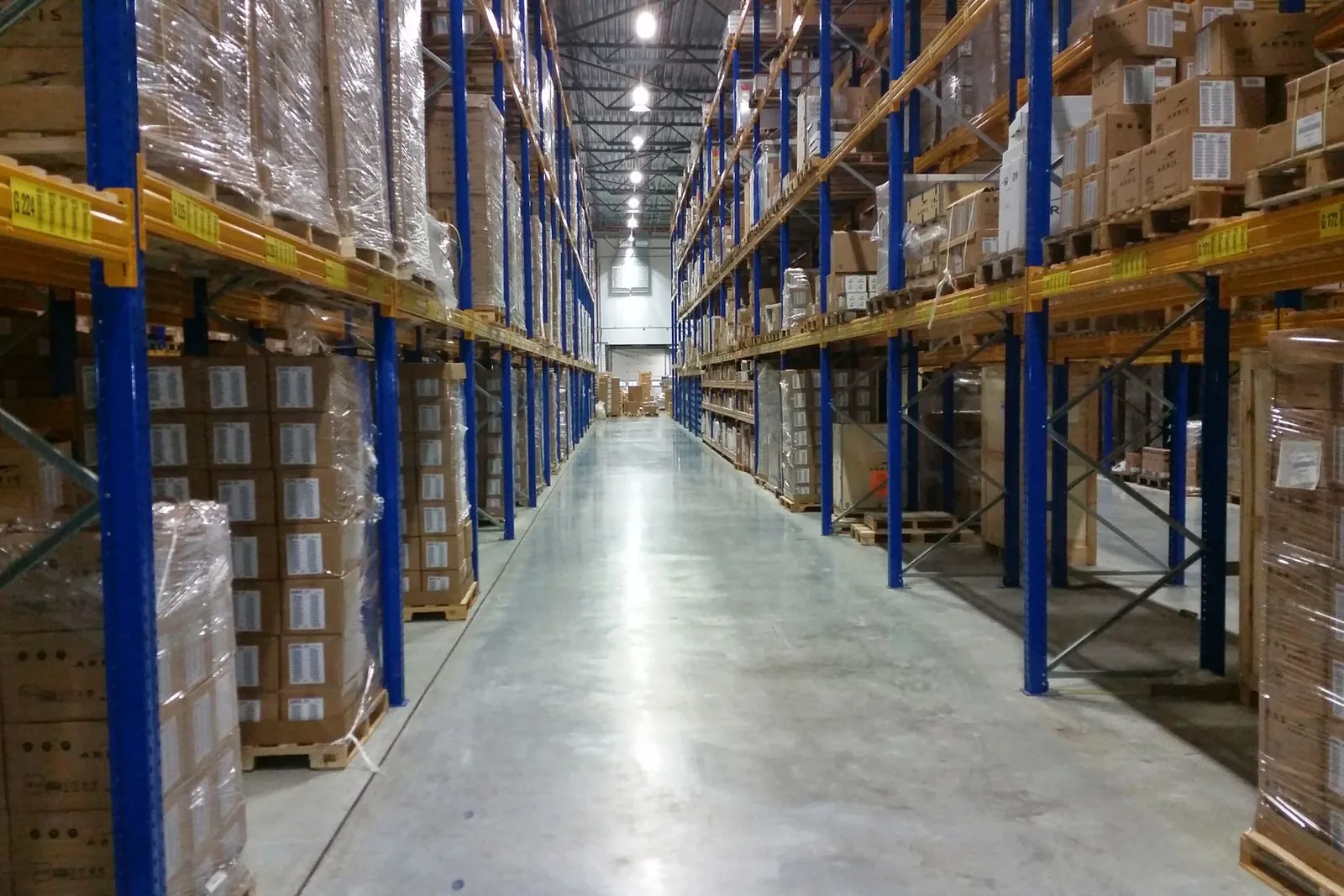 Cardboard boxes of stock on shelves in a warehouse